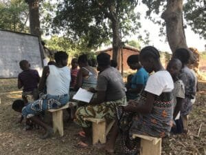 Adult literacy class held outside.